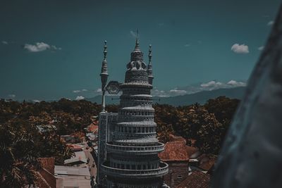 Tower amidst buildings in city against sky