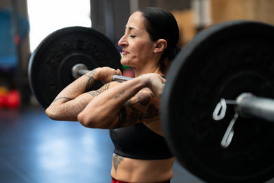 Side view of woman exercising in gym