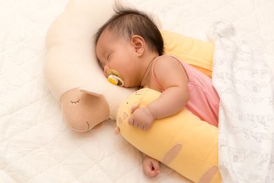 Close-up of baby girl on bed