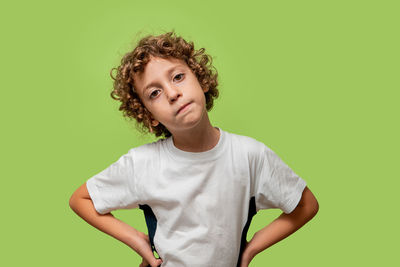 Portrait of teenage boy against green background