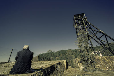 Rear view of man on landscape against clear sky