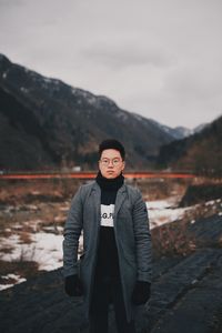 Portrait of man standing against mountains