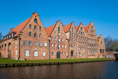 Building by river against sky