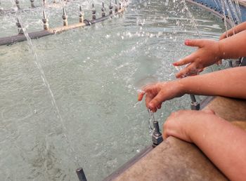 High angle view of hand splashing water in swimming pool