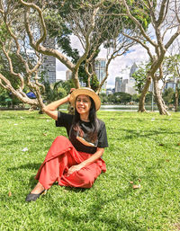 Portrait of young woman sitting on grassy field