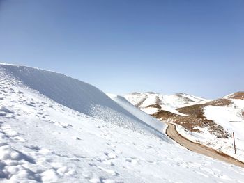 Scenic view of snowcapped mountains against clear sky