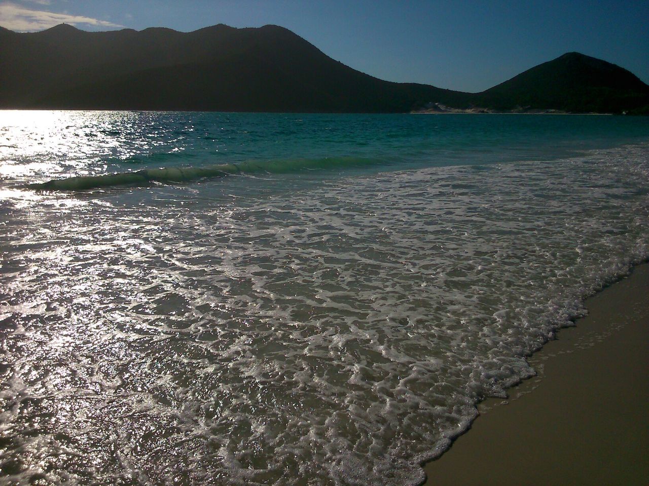 water, mountain, tranquil scene, sea, scenics, tranquility, beauty in nature, mountain range, nature, reflection, idyllic, beach, lake, sky, coastline, shore, outdoors, non-urban scene, waterfront, no people