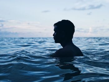 Woman swimming in sea against sky