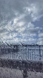 Close-up of frozen water against sky