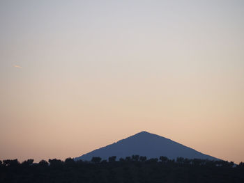 Scenic view of silhouette mountains against clear sky during sunset