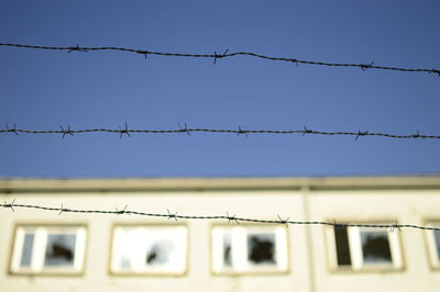 Low angle view of barbed wire against clear sky