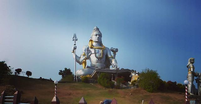 statue, human representation, sculpture, art and craft, art, creativity, clear sky, low angle view, religion, copy space, spirituality, craft, blue, sky, carving - craft product, animal representation, temple - building