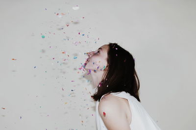 Low section of woman with balloons against white background