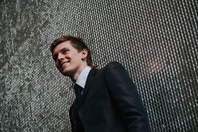 Handsome man standing against wall