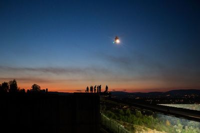 Silhouette city against clear sky during sunset