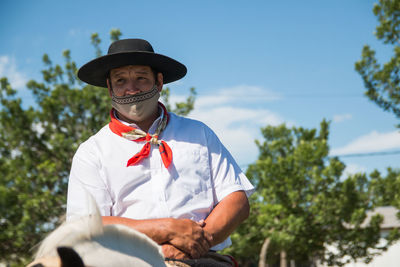 Argentinian man riding horse with face mask