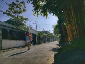 Rear view of man on road amidst trees