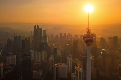 Aerial view of buildings in city during sunset