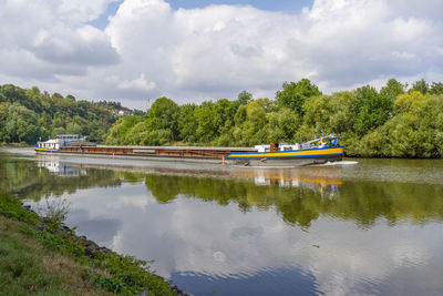 Cargo ship on a river at summer time in sunny ambiance