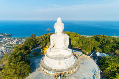 Statue by sea against sky