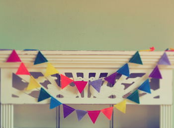 Close-up of multi colored flags hanging against wall