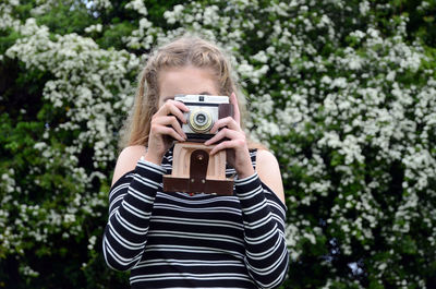 Digital composite image of woman holding camera