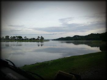 Calm lake with trees in background