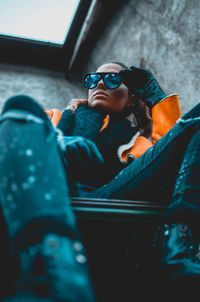 Low angle view of woman in sunglasses sitting at home