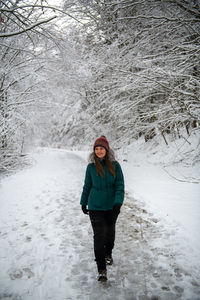 Rear view of woman walking on snow covered landscape