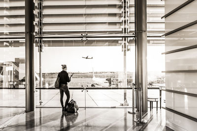 Rear view of woman standing at airport