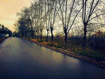 Road by river against sky during sunset