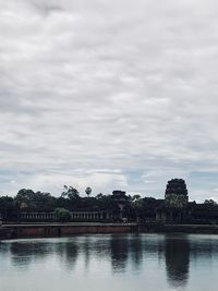 Buildings by lake against sky