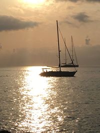 Sailboat sailing on sea against sky during sunset