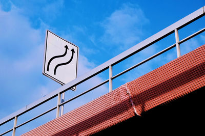 Low angle view of bridge sign against blue sky