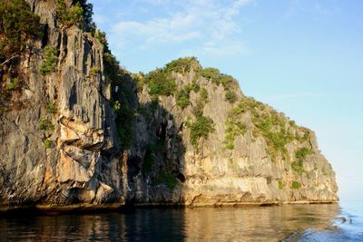 Rock formations by sea against sky