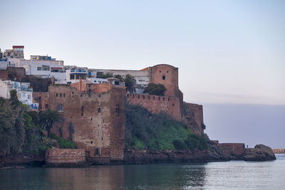 Historic building by sea against sky