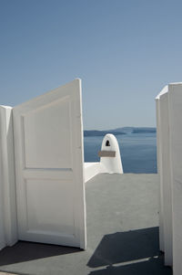 White wooden door overlooking the mediterranean sea in the village of oia, greece. 