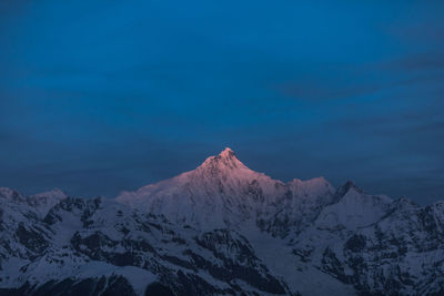 Scenic view of snowcapped mountains against blue sky