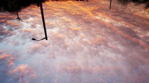 Silhouette vapor trail against sky during sunset