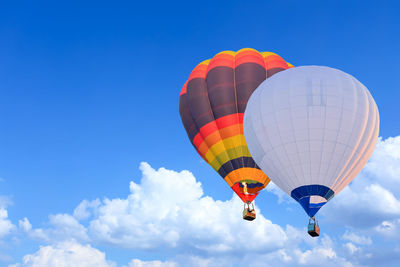 Low angle view of hot air balloons against blue sky