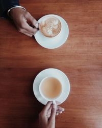 Person holding coffee cup on table