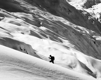 Low angle view of silhouette man hiking on snowcapped mountain