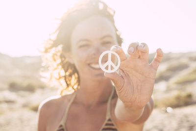 Portrait of woman holding hands at beach