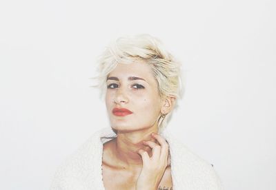 Portrait of young woman against white background