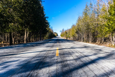 Road amidst trees against clear sky