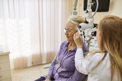 Ent physician examining ear of a senior woman