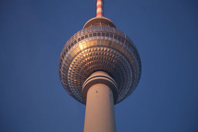 Low angle view of communications tower against blue sky