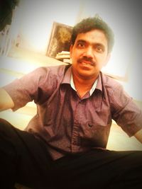 Portrait of young man sitting at home