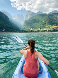 Rear view of woman in boat against mountains