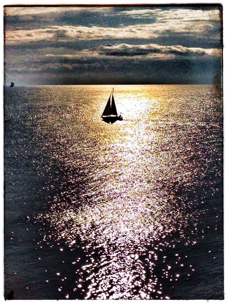 SAILBOAT IN SEA AGAINST SKY AT DUSK